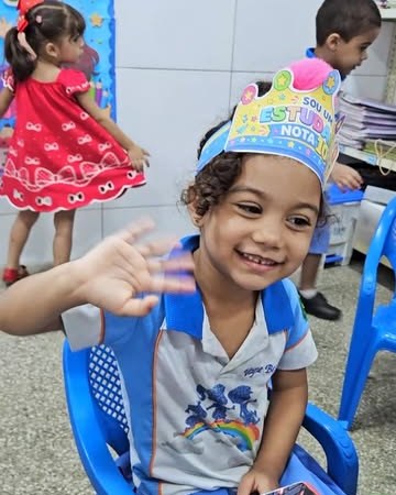 Aluno da Escadinha do Saber sorrindo em atividade na sala